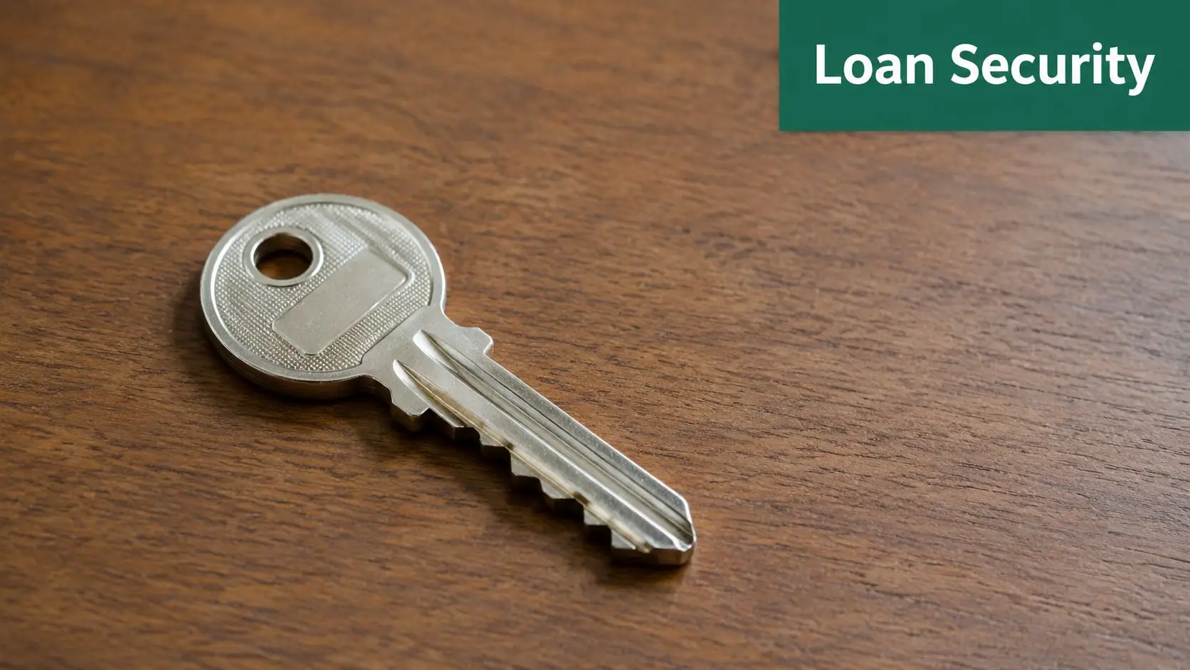 A silver metal door key lying on a textured wooden table surface representing financial loan security.